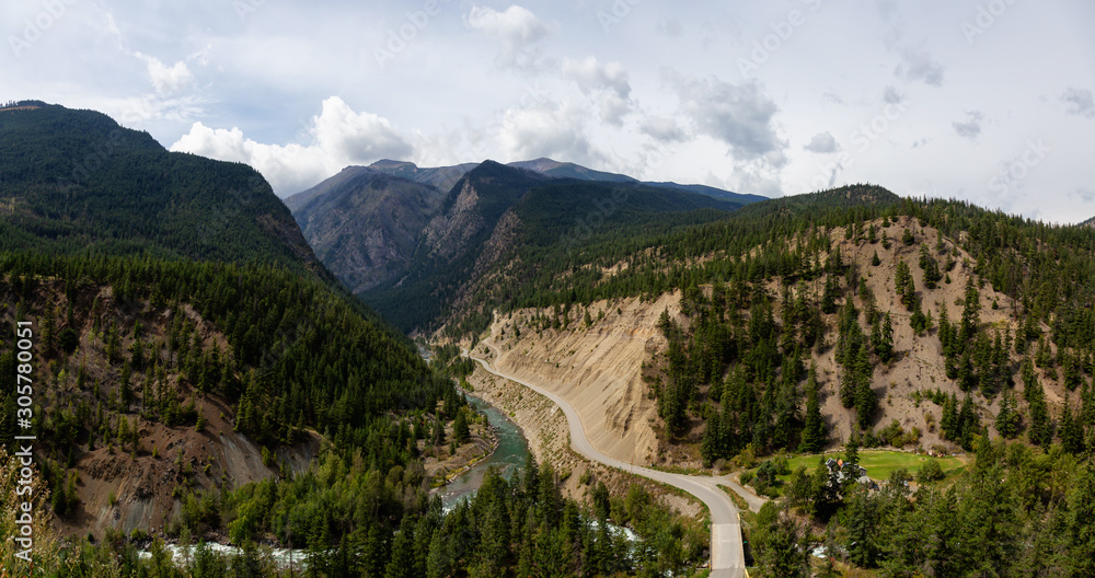 Aerial Panoramic View of a Scenic Dirt Road towards Gold Bridge in the Valley surrounded by Canadian Mountain Landscape. Taken near Lillooet, British Columbia, Canada.