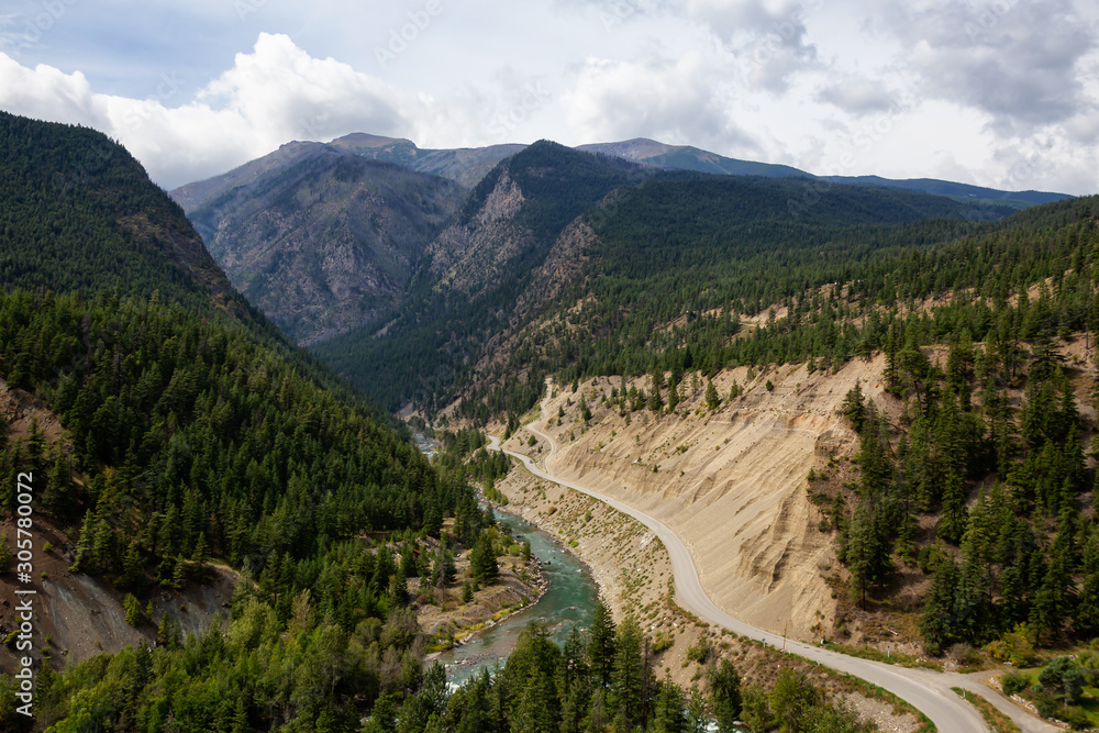Aerial View of a Scenic Dirt Road towards Gold Bridge in the Valley surrounded by Canadian Mountain Landscape. Taken near Lillooet, British Columbia, Canada.