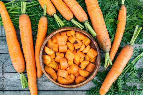 fresh carrots on wooden table after harvesting, cooking for vegetarians, healthy food. Growing vegetables in garden