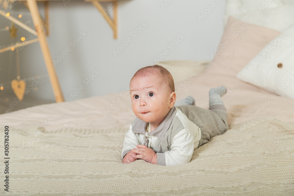 Cute little boy in the New Year's room on the bed. Cute little boy in the New Year's room on the bed.