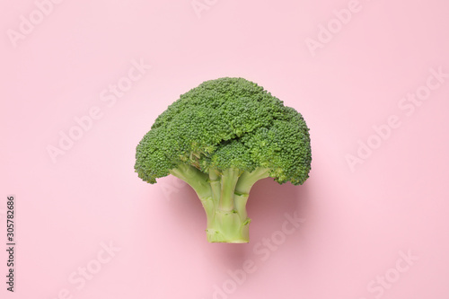 Fresh tasty broccoli on pink background, top view