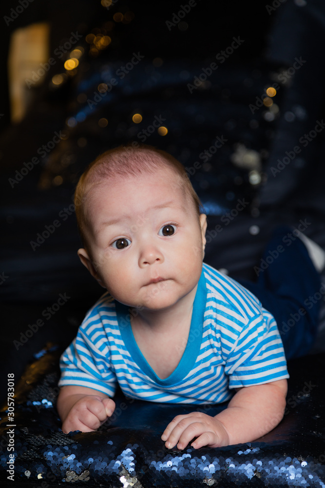 Beautiful little boy on the bed in a cozy setting. Beautiful little boy on the bed in a cozy setting.