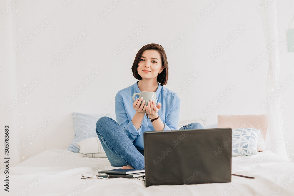 Businesswoman working on her laptop in the white bed. Work at home. Freelancer Businesswoman working on her laptop in the white bed. Work at home. Freelancer
