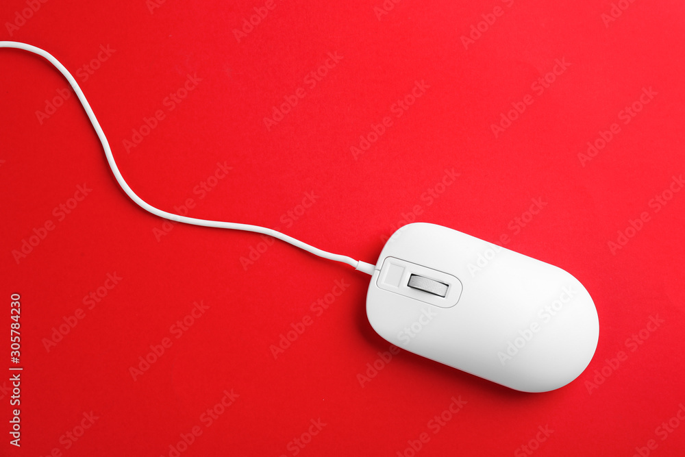 Modern wired optical mouse on red background, top view Modern wired optical mouse on red background, top view