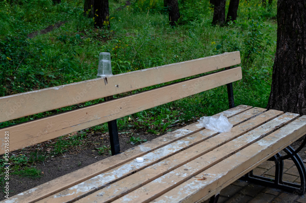 Environment pollution concept. Plastic garbage cup pollution on the beach. Used plastic cup waste on bench Environment pollution concept. Plastic garbage cup pollution on the beach. Used plastic cup waste on bench