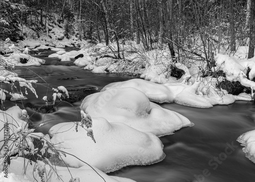 Water stream during winter with snow and trees