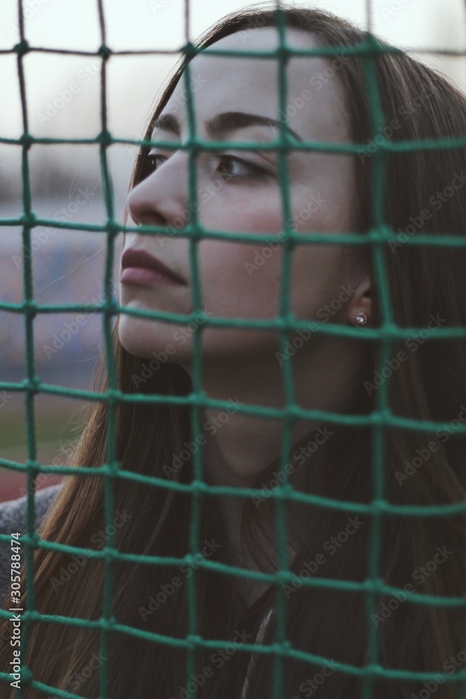 Sensual portrait of beautiful young girl walking in the old abandoned stadium on cold autumn day