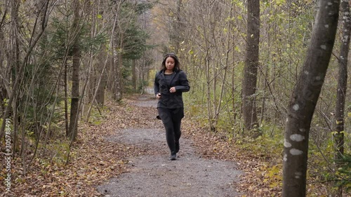Wallpaper Mural Woman puts on her headphones and starts to jog on a small path through the forest Torontodigital.ca