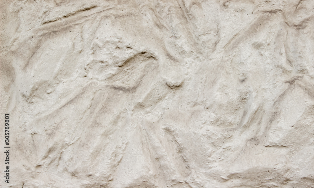 Obraz premium A decorative wall with a wavy structure painted in beige