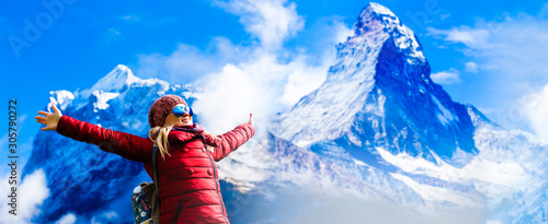Woman with red hat looking at winter mountains Matterhorn