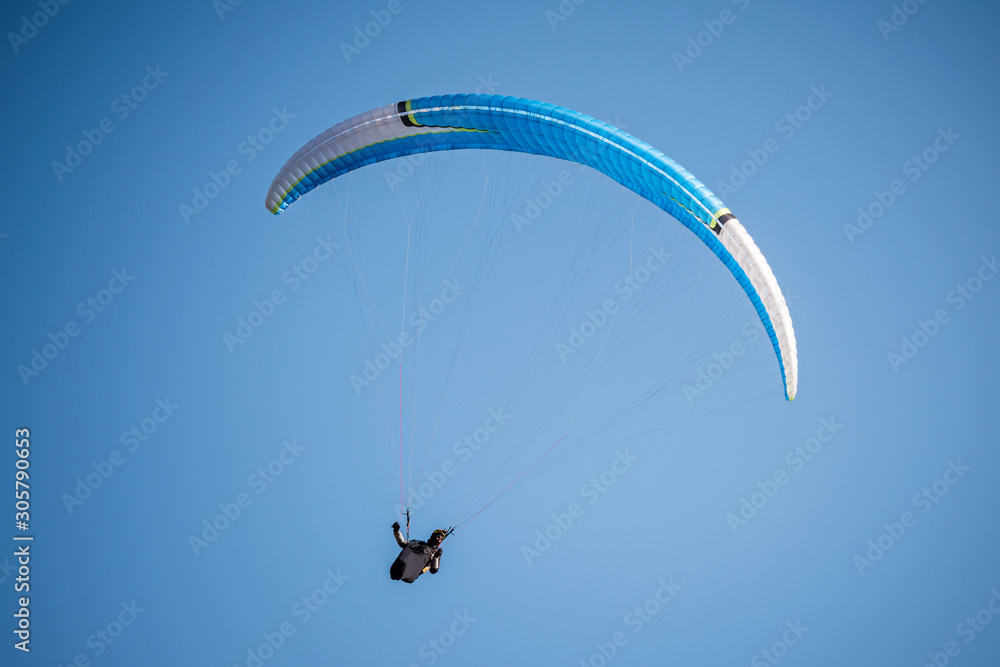 paraglider flying in the blue sky. Italian Alps. Piedmont. Italy paraglider flying in the blue sky. Italian Alps. Piedmont. Italy