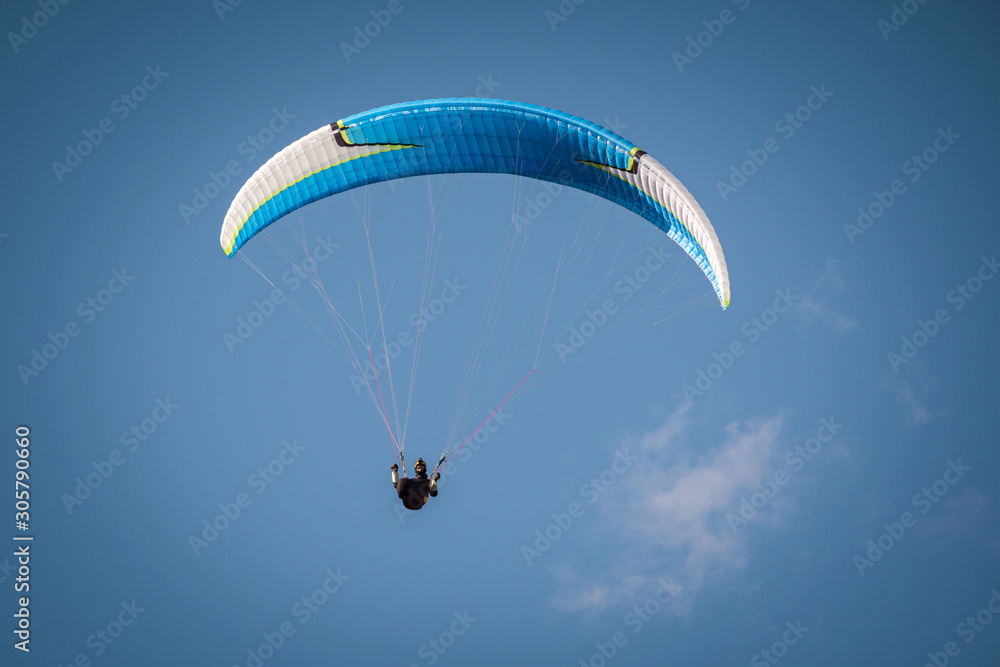 paraglider flying in the blue sky. Italian Alps. Piedmont. Italy paraglider flying in the blue sky. Italian Alps. Piedmont. Italy