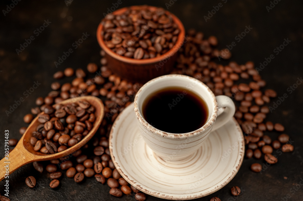 Fototapeta premium Cup of coffee and different beans on a stone background.