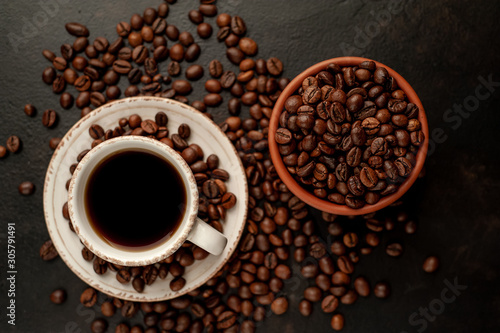 Cup of coffee and different beans on a stone background.