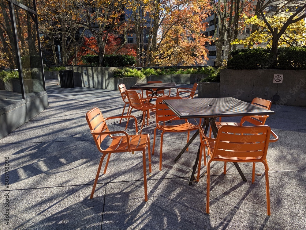 Orange patio chair and table set outside in a busy downtown area in Bellevue, Washington.