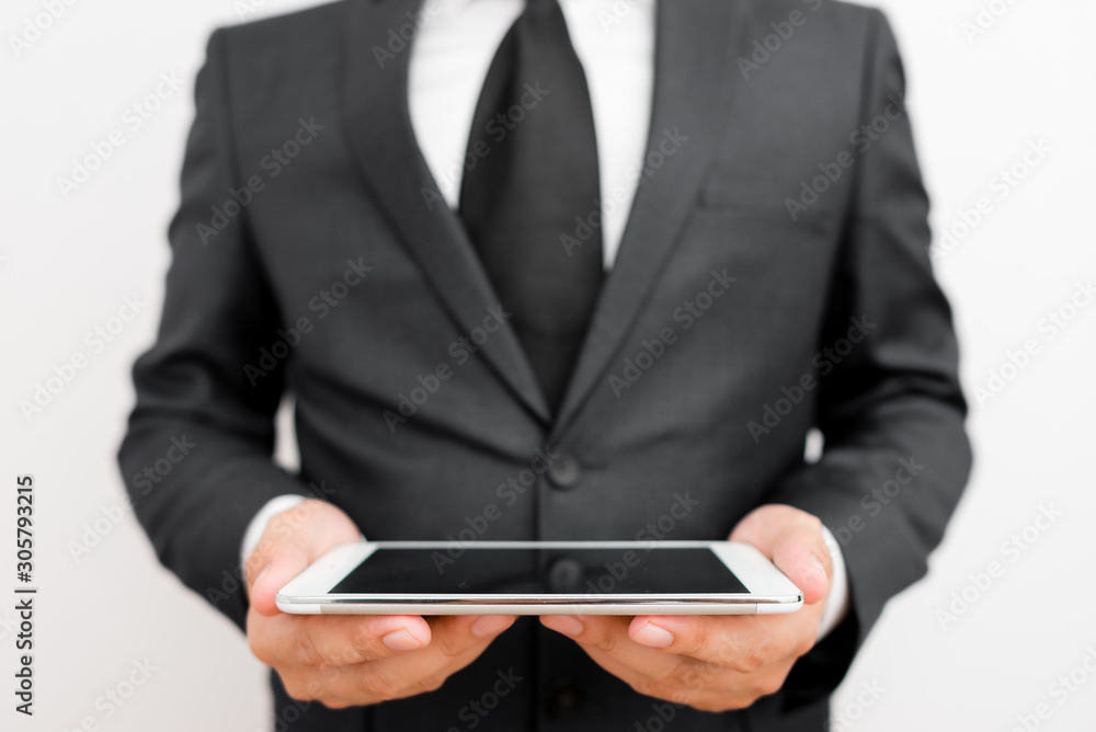 Male human wear formal work suit hold smart hi tech smartphone use hands Male human wear formal work suit hold smart hi tech smartphone use hands