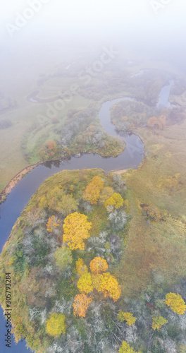 Forest in autumn colors. Colored trees and a meandering blue river. Red, yellow, orange, green deciduous trees in fall. Peetri river, Estonia, Europe photo