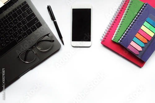 Obraz na płótnie Desk with laptop, eye glasses, pen and smartphone screen. Top view with copy space. w salonie