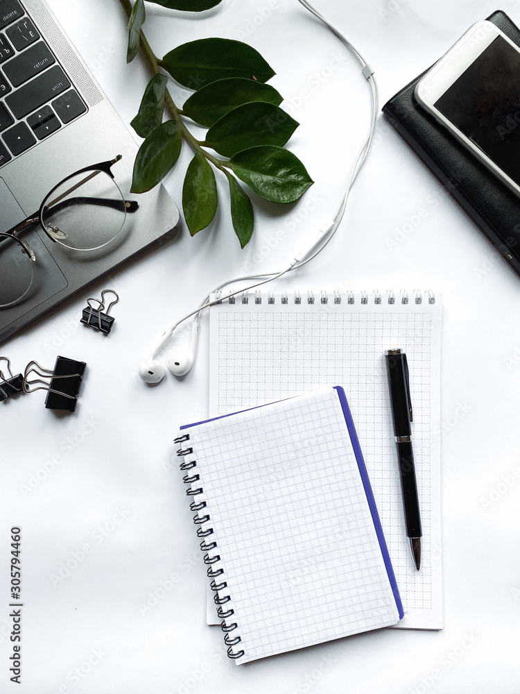 Desk with laptop, eye glasses, pen and workbooks. Top view with copy space.