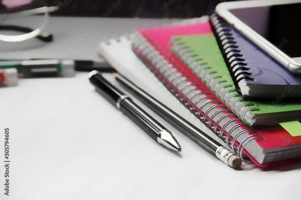 Desk with laptop, eye glasses, pen and workbooks. Top view with copy space.