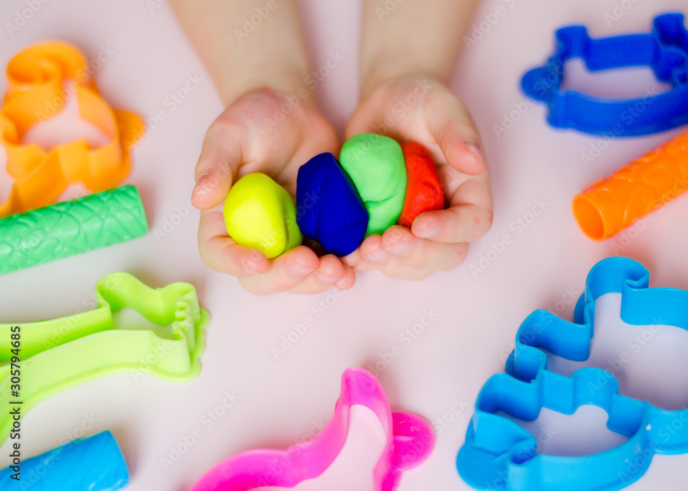 Child hands playing with colorful clay. Homemade plastiline