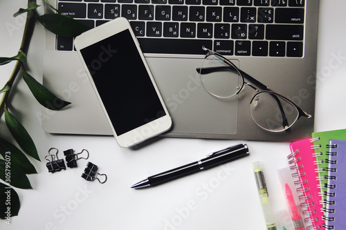 Obraz na płótnie Desk with laptop, eye glasses, pen and smartphone screen. Top view with copy space. w salonie