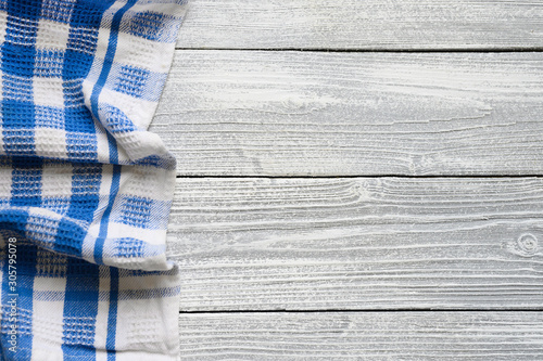 checkered white blue kitchen towel on white wood background. top view, flat lay, space for text.