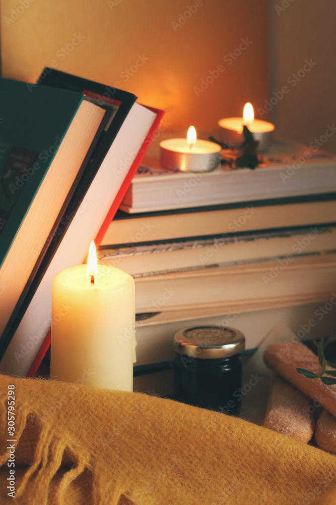 Books and candles, autumn home comfort and warm light