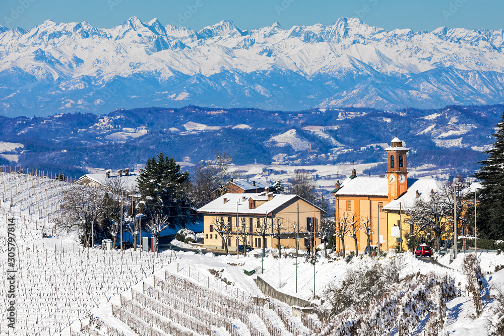 Rural house and parish church covered in snow in Italy.