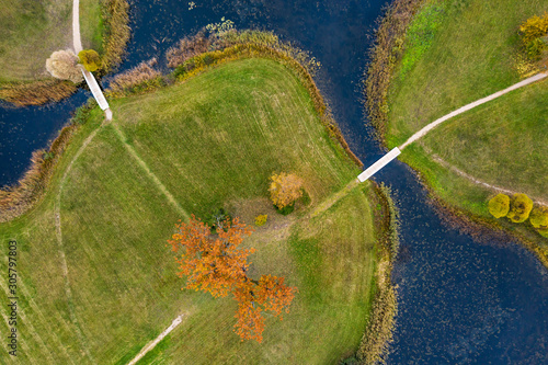 Fototapeta Naklejka Na Ścianę i Meble -  Island in the lake and forest in autumn colors. Golden trees and a blue water, nature environment. Sundown evening light in fall.