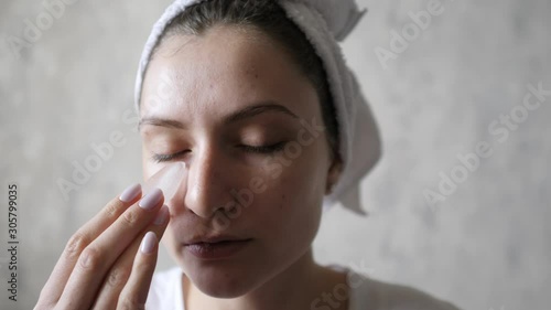 A woman uses ice to smooth wrinkles and lift skin under her eyes. Hydration in cosmetology. Melting ice in the hands of a beautiful young woman
