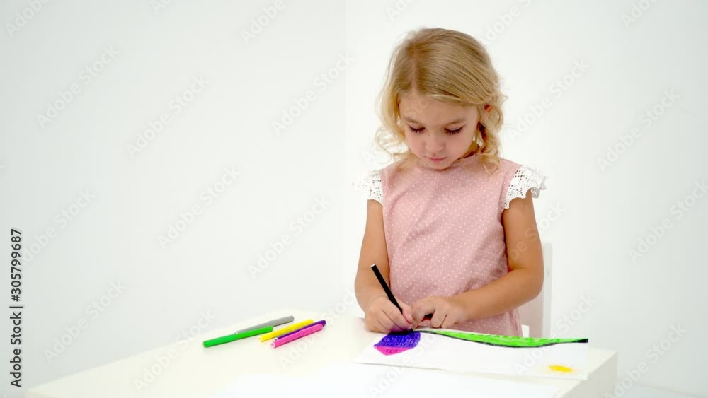 A little girl is drawing at the table. A little girl is drawing at the table.