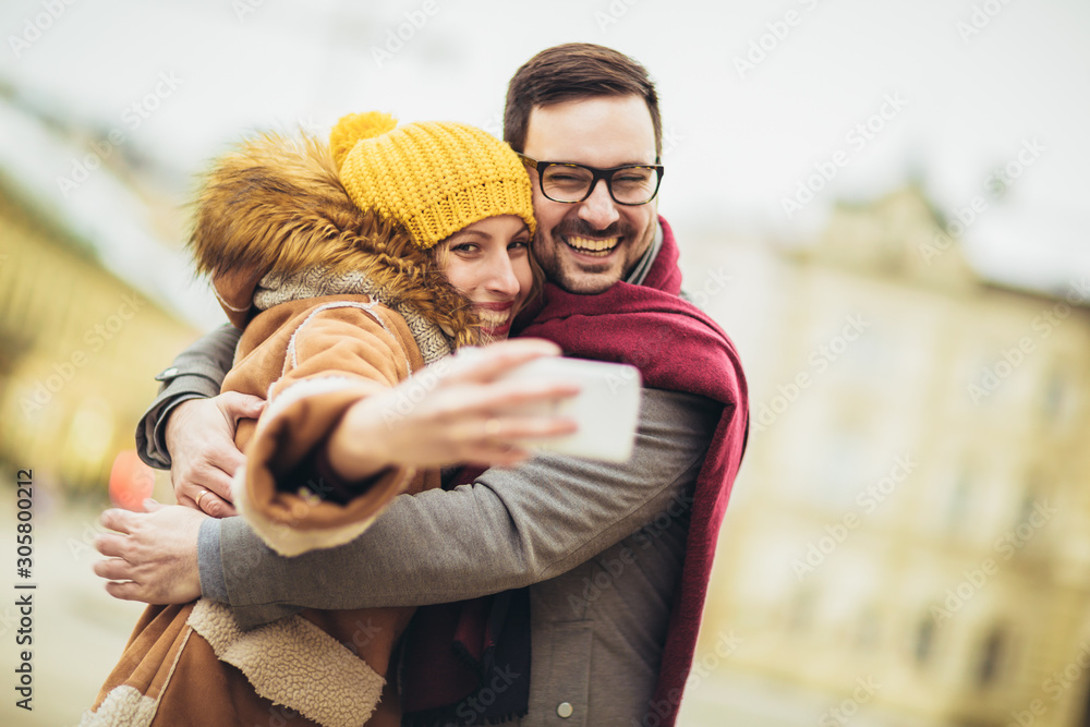 Young beautiful couple make selfie photo in the city.