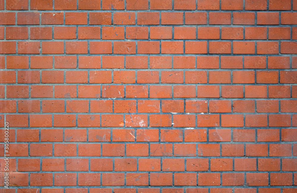 Obraz premium old red ragged brick wall with gray cement, stains of white paint and cracks. rough surface texture