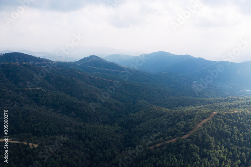 Cyprus mountain landscape aerial view in fog, mist or low lying clouds in sunlight. Beautiful mediterranean nature panorama.