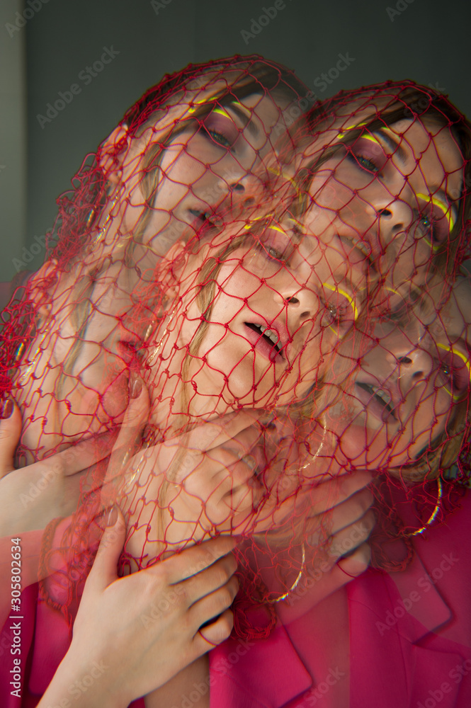 sexy woman with bright pink clothes, nets on head Conceptual color photography in kaleidoscope.. Fashion style