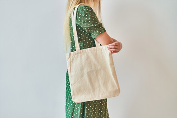 A Girl is holding blank cotton eco tote bag, design mockup.