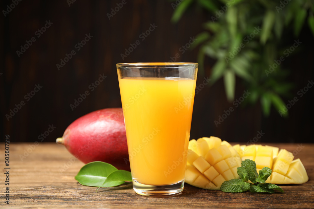 Fresh delicious mango drink on wooden table Fresh delicious mango drink on wooden table