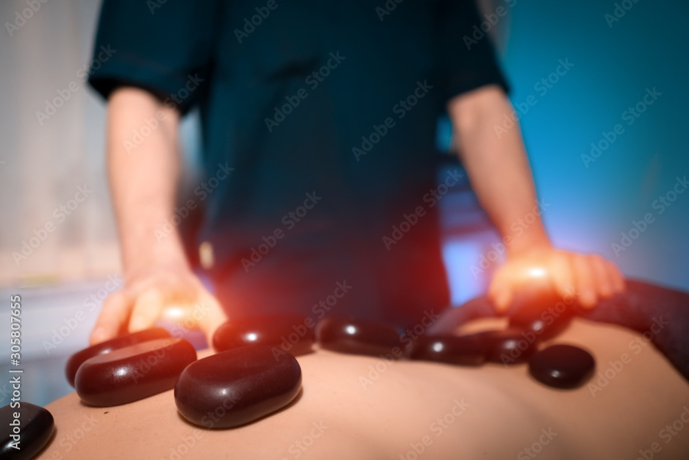 masseur making healing stone massage for womans spine masseur making healing stone massage for womans spine