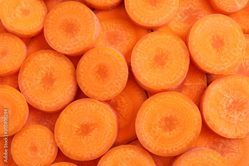 Slices of fresh ripe carrot as background, top view