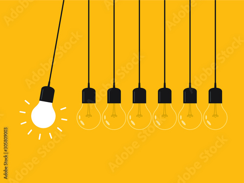 Newton's cradle with glowing light bulb. Pendulum. Leadership, power and uniqueness concept.