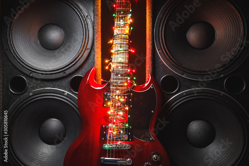 electric guitar with festive Christmas lights and music speakers