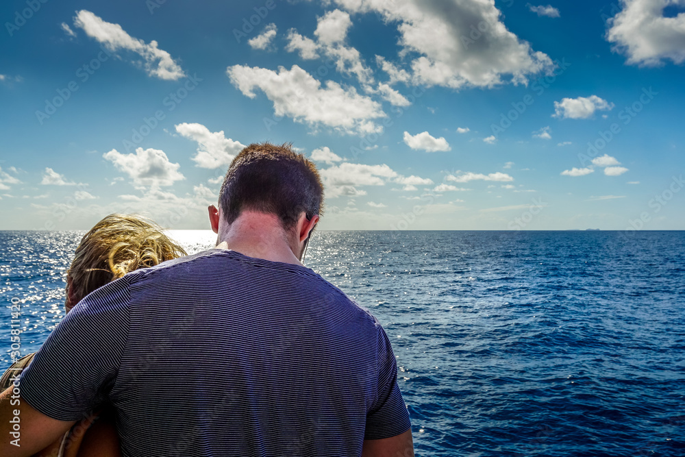 A young couple standing together on a boat and admiring the beautiful view. A young couple standing together on a boat and admiring the beautiful view.