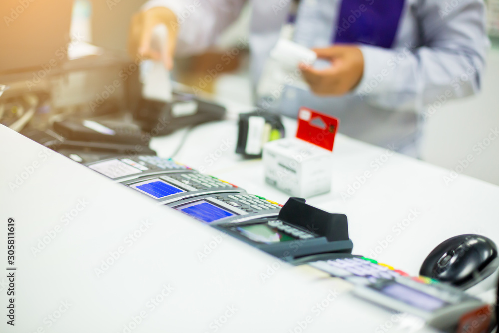Selective focus to many credit card reader with blurry cashier do payment at counter service, credit card payment, buy and sell products & service, the concept of payment, Business background.