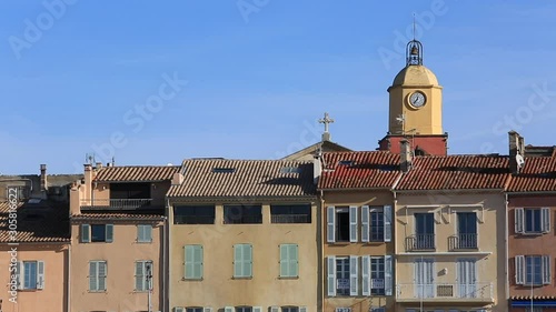 Slow motion footage of a bird flying in front of iconic buildings in Saint Tropez in South of France