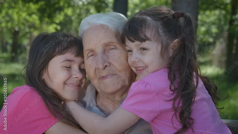Smile of grandma. Happy little girls hug grandmother in a summer park. Smile of grandma. Happy little girls hug grandmother in a summer park.