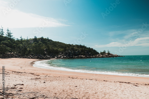 Sunny beach on Magnetic island  Australia with rocks and hills around