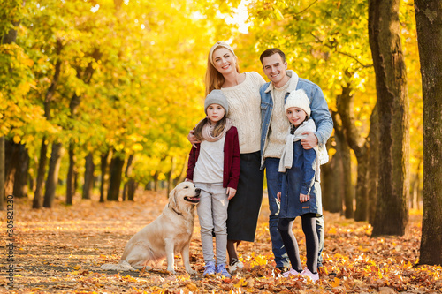 Happy family with dog in autumn park