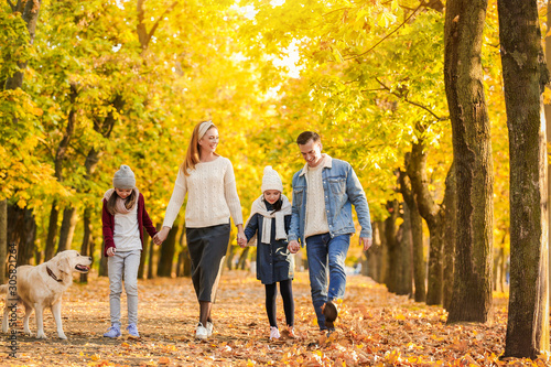 Happy family walking in autumn park