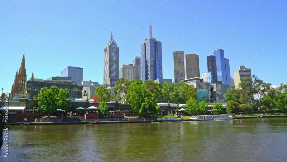 Look over the Yarra river with people walking at the quay in the center of Melbourne Look over the Yarra river with people walking at the quay in the center of Melbourne